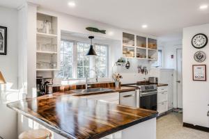 a kitchen with white cabinets and a wooden counter top at Sunny Days in Brewster