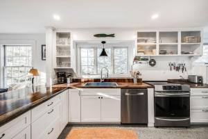 a kitchen with white cabinets and a sink at Sunny Days in Brewster