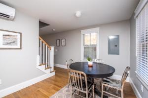 a dining room with a black table and chairs at Cod Hollow in Provincetown