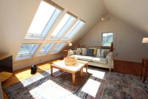 a living room with windows and a couch and a table at High Tide Upper Level in Provincetown