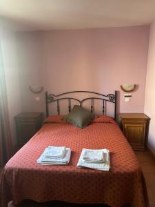 a bedroom with a bed with two towels on it at Hotel Cadalso - Casa Moncho in Cadalso de los Vidrios