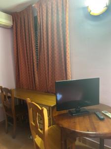 a table with a computer monitor on top of it at Hotel Cadalso - Casa Moncho in Cadalso de los Vidrios +8 photos