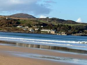 a view of the beach with a town in the background at Shanawee in Gleneely