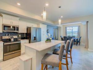 a kitchen with white cabinets and a table and chairs at Gorgeous 2BR lakeview Condo with Waterpark in Kissimmee