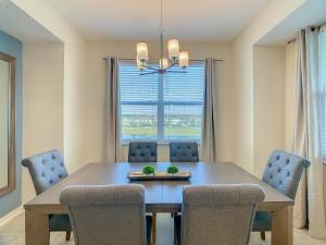 a dining room with a table and chairs and a window at Gorgeous 2BR lakeview Condo with Waterpark in Kissimmee