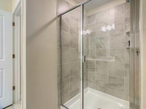 a shower with a glass door in a bathroom at Gorgeous 2BR lakeview Condo with Waterpark in Kissimmee