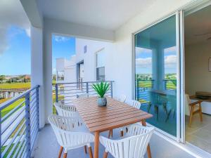 a wooden table on a balcony with white chairs at Gorgeous 2BR lakeview Condo with Waterpark in Kissimmee +84 photos