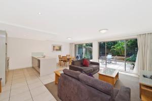 a living room with a couch and a table at Beach Resort Apartment in Port Macquarie
