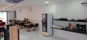 a restaurant with people sitting at tables and a soda machine at Hotel Arco-Íris in Itapipoca +23 photos