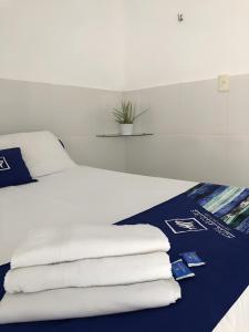 a bed with white sheets and towels on it at Hotel Arco-Íris in Itapipoca