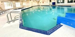 a large swimming pool with blue tiles on the floor at Holiday Inn Express Airdrie by IHG in Airdrie