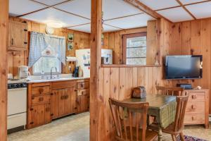 a kitchen with wooden walls and a table and a television at Anchors Aweigh in Brewster