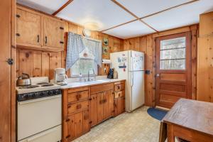 a kitchen with wooden cabinets and a white refrigerator at Anchors Aweigh in Brewster