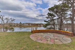 a stone bench sitting in front of a lake at Aweigh We Go in Chatham +34 photos