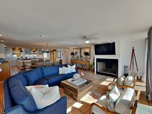 a living room with a blue couch and a fireplace at Blue Heron in Pensacola Beach
