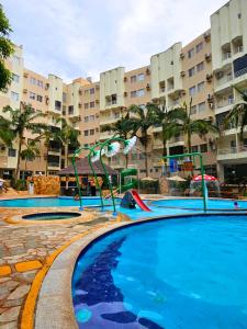 an empty swimming pool with a slide in a resort at Thermas Paradise Residence in Rio Quente