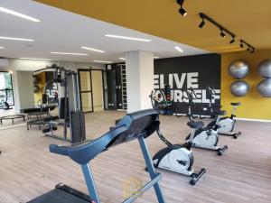 a gym with three elliptical machines in a room at Studio Comfort apartament Arujá in Arujá
