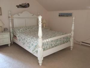 a bed in a bedroom with a white bed frame at Bayside Bliss in Dennis
