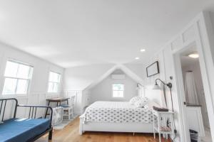 a white bedroom with a bed and a blue couch at Harbor Breeze Townhouse in Provincetown +14 photos