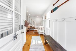 a hallway with a bench and a dining room at Harbor Breeze Townhouse in Provincetown
