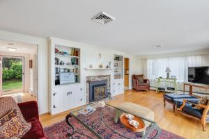 a living room with a fireplace and a tv at Le Petit Château in Dennis