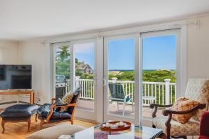 a living room with sliding glass doors at Le Petit Château in Dennis