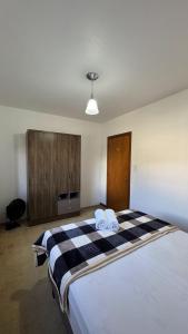 a bedroom with a large bed with two towels on it at Apto 2D ensolarado, sacada e garagem, centro in Nova Petrópolis