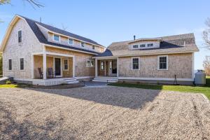 a house with a gravel driveway in front of it at Sea Winds in Brewster