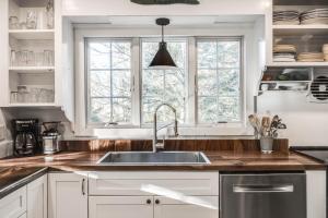 a kitchen with a sink and two windows at Sunny Days in Brewster