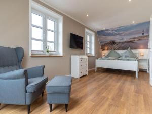 a bedroom with a bed and a chair and a couch at Doppelhaushälfte in Karolinenkoog in Karolinenkoog