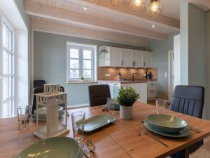 a dining room with a wooden table and a kitchen at Doppelhaushälfte in Karolinenkoog in Karolinenkoog
