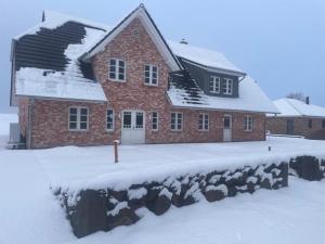 a red brick house with snow on the ground at Doppelhaushälfte in Karolinenkoog in Karolinenkoog