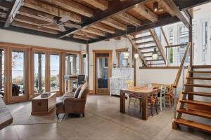 a living room with wooden ceilings and a table and chairs at The Grand On Commercial in Provincetown +16 photos