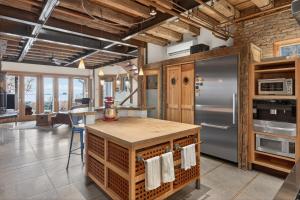 a kitchen with an island and a refrigerator at The Grand On Commercial in Provincetown