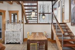 a dining room with a wooden table and stairs at The Grand On Commercial in Provincetown