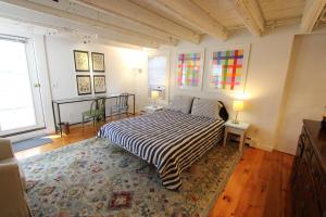 a bedroom with a bed and two tables and two windows at High Tide Lower Level in Provincetown +6 photos
