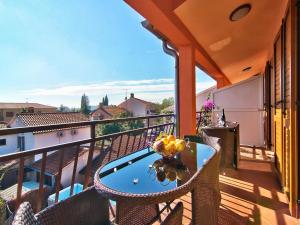 a balcony with a table with a bowl of fruit on it at Apartments Cvek in Rovinj
