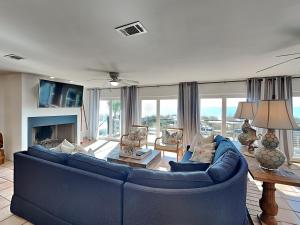 a living room with a blue couch and a fireplace at Blue Heron in Pensacola Beach