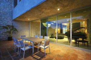 a dining room with a table and chairs and a piano at Casa Piedra Villa in Cancún