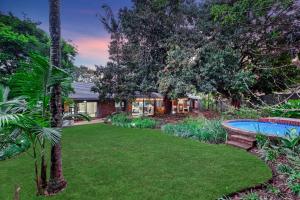 a yard with a pool and a house at Honeysuckle in Tzaneen