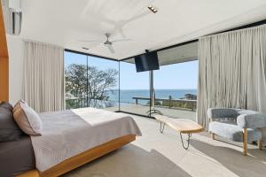 a bedroom with a bed and a view of the ocean at Infinity Pool Villa , 4 Suites & Private Casita in Tamarindo