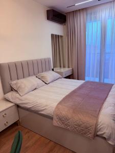 a bedroom with a large bed with a large window at next apartment lux in Batumi