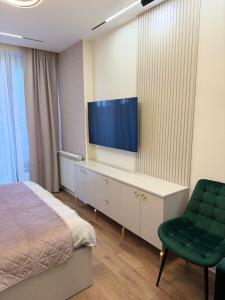 a hotel room with a bed and a tv on a wall at next apartment lux in Batumi