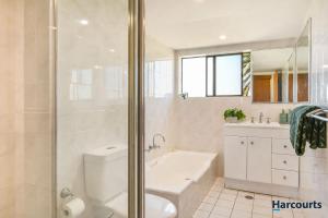 a bathroom with a shower and a toilet and a sink at Beachside Bliss in Port Macquarie