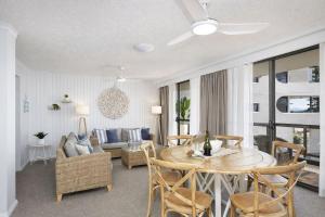 a living room with a table and chairs and a couch at Beachside Bliss in Port Macquarie