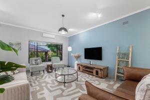 a living room with a couch and a tv at Honeysuckle in Tzaneen