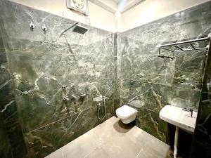 a bathroom with a shower and a toilet and a sink at Markandey Bhavan in Deoghar +18 photos