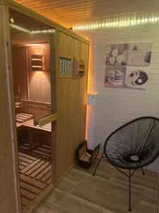 a hallway with a chair and a room with a tub at Arboréa, charmant loft in Mirebeau-sur-Bèze
