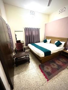 a bedroom with a bed and a chair in it at Markandey Bhavan in Deoghar