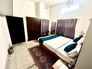 a bedroom with a bed with blue pillows on it at Markandey Bhavan in Deoghar